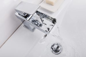 The modern and new steel faucet with the ceramic bathtub  in the bathroom